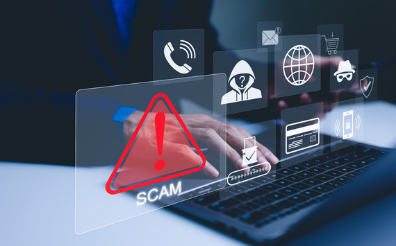 Scam Alert - Person using laptop with scam/phishing pop-ups