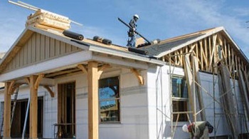 Construction worker on roof of house