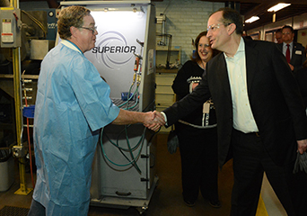 Secretary of Labor Alexander Acosta (right) meets with a worker at the Raytheon Precision Manufacturing facility in Dallas.