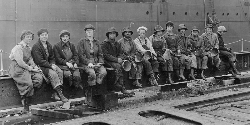 Women workers sitting on steel beam circa 1920