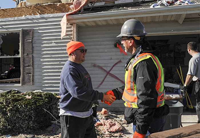 An OSHA inspector consults with a worker during storm recovery operations.