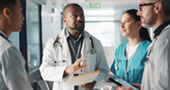 workers at a hospital meeting while standing