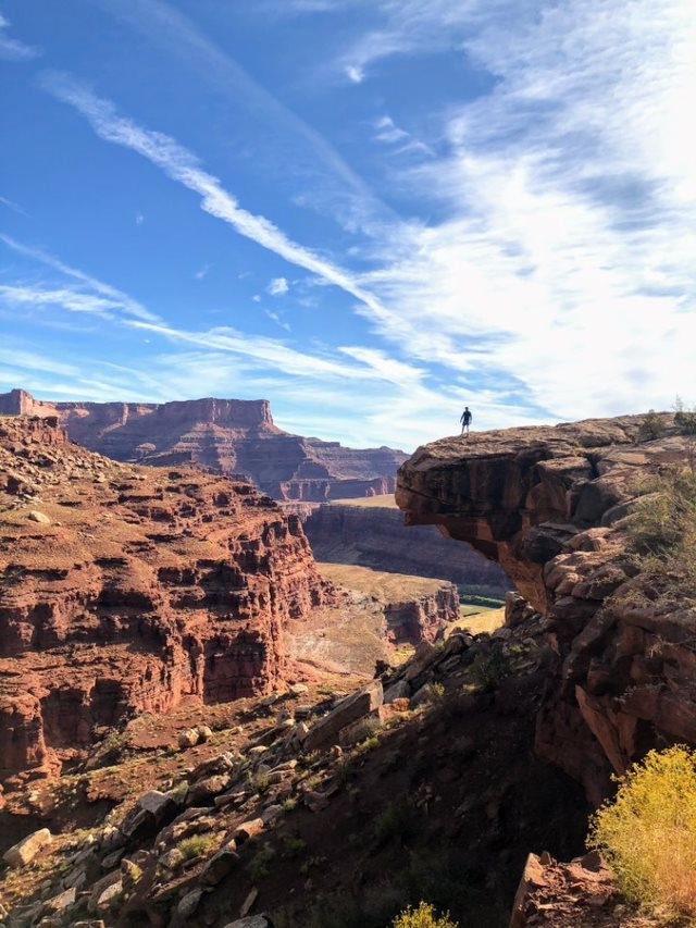 Person standing on a cliff in the distance. 