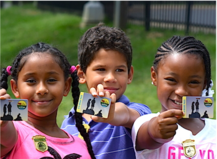 Three children holding up a card