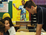 Teacher Sean McComb interacting with two students