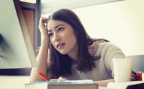 Student staring at a computer with a worried expression