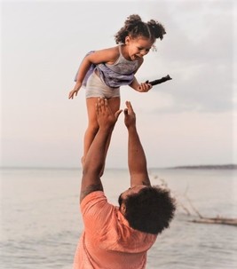 Summer Fun: dad throwing daughter in the air