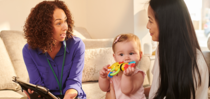 Specialist conversing with a mother with her infant daughter