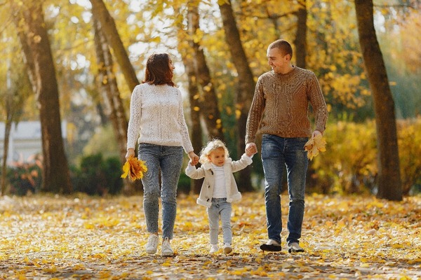 Couple walking with young girl in fall countryside