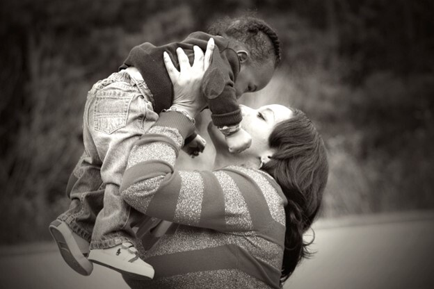 A mother holding her toddler up in the air