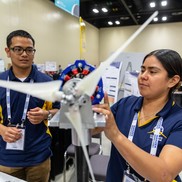 Two competitors work on their wind turbine at a previous Collegiate Wind Competition.