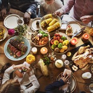 A group of people sit around a table full of food. 