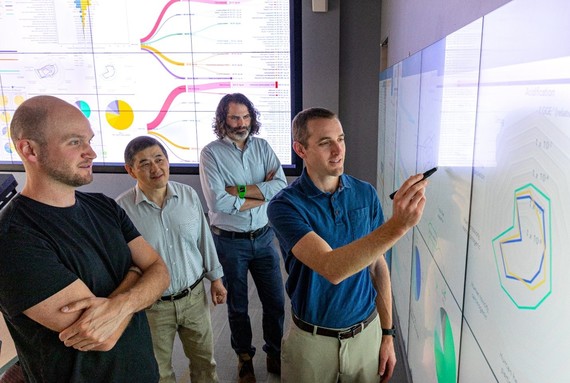 Image of researchers looking at a whiteboard. 