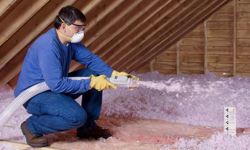 A man insulating an attic