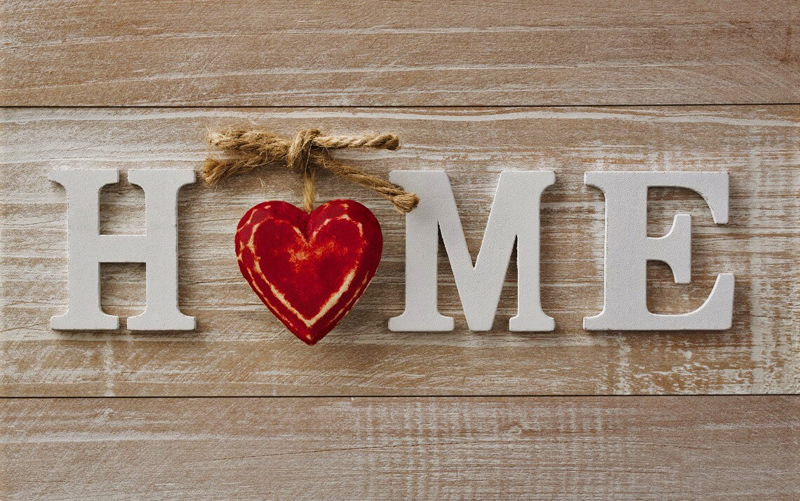 The word "home" displayed in white wooden letters