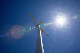 Sun shining on a wind turbine.