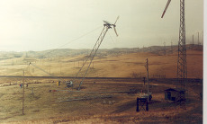 A wind turbine being installed with other turbines standing nearby.
