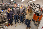 Four scientists stand in front of the Alder Renewable's distillation skid