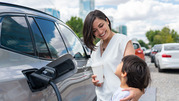 Woman and child charging electric vehicle