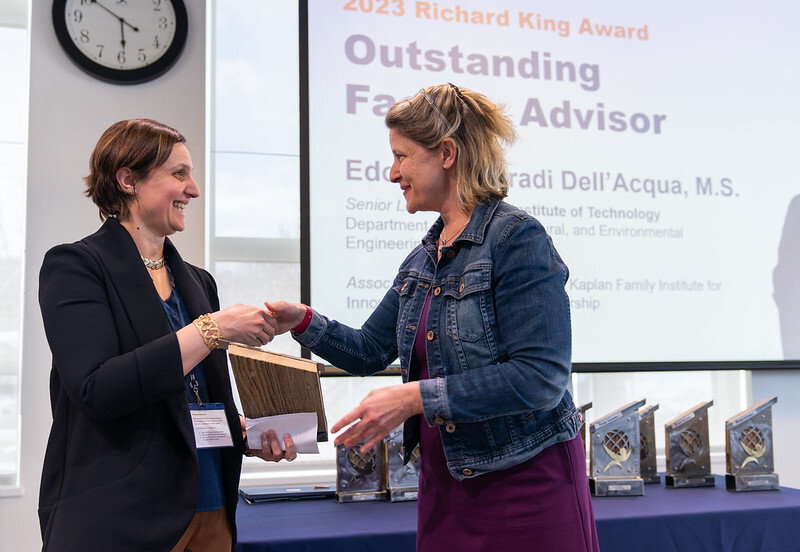 A photo of Holly Carr shaking hands with the 2023 Outstanding Faculty Advisor award winner: Edoarda Corradi Dell'Acqua,