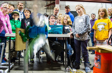 Kids surround a computer and model wind turbine 