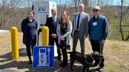 Officials pose in front of new NEVI station. 