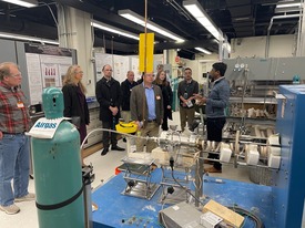 A group of people in protective goggles standing in a facility