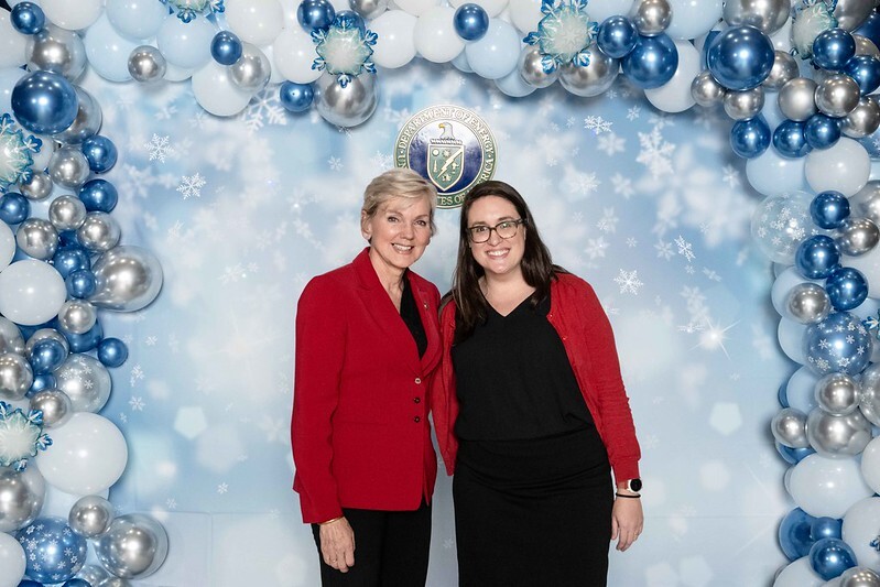 Two people in front of a snowflake background