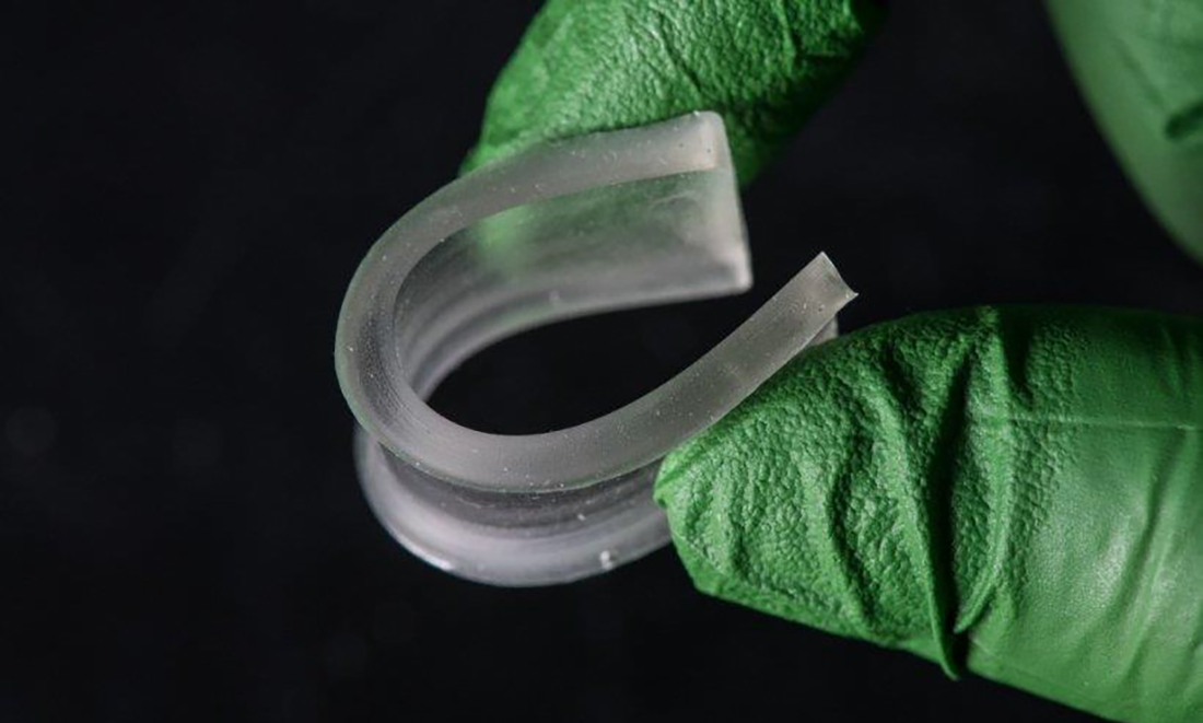 Gloved hand holding rubbery polymer