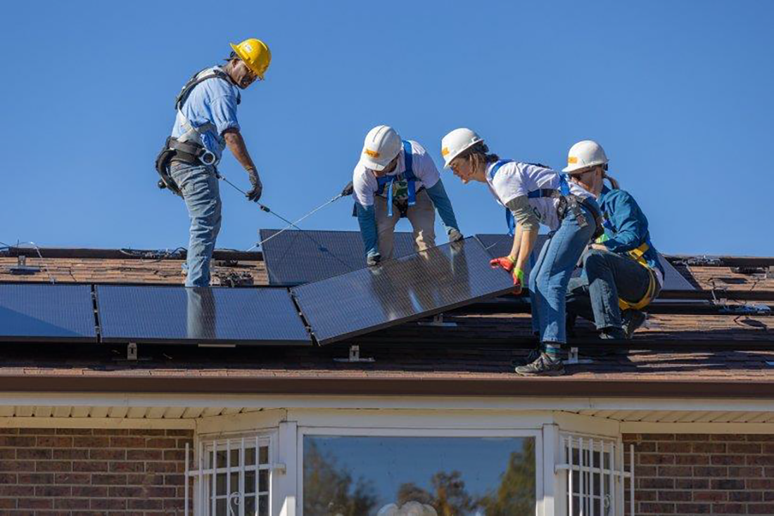 Team installs solar panels on roof
