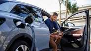 Image of man sitting in his EV while it charges