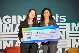 Two women holding a check on stage