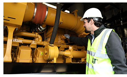 Caterpillar (Cat) industrial generator set being inspected. 