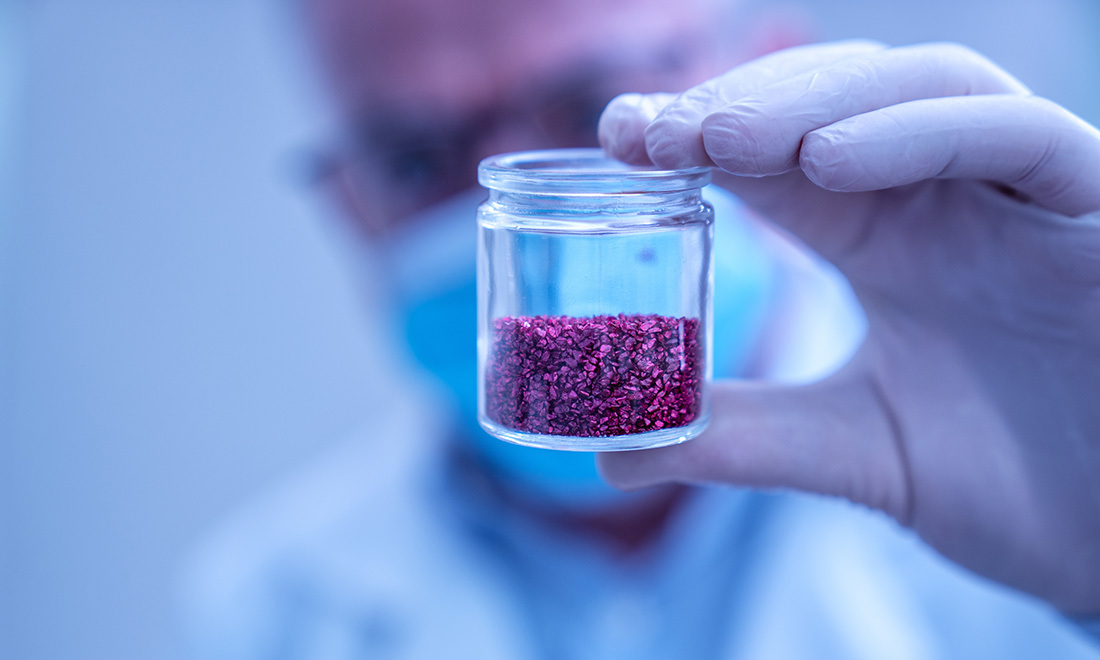 Scientist holding jar with rare earth elements