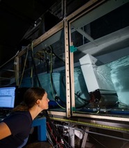 Woman looks up into a wave tank inside a lab