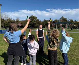 Children holding up air quality flags in a field. 