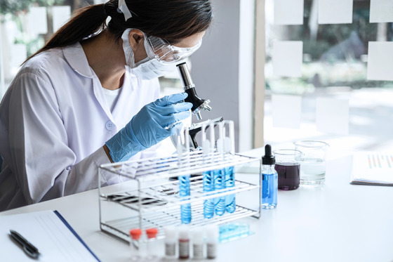 Water laboratory scientist looking through microscope at a water sample