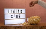 coming soon sign with bowl of popcorn