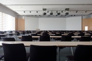 large lecture hall with multiple empty chairs and tables