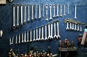 A set of wrenches and other miscellaneous tools on a wall