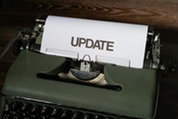Green Classic Typewriter with White Paper with the word "update"