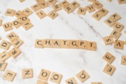 Wooden blocks with letters arranged to spell "CHATGPT"