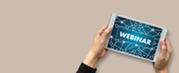 A person holds a tablet displaying the word “Webinar” over a connected network graphic on a neutral background.