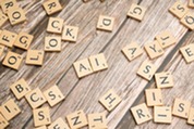 Wooden letter tiles scattered on a table with two arranged to spell "AI", symbolizing learning, skills, and professional development concepts.