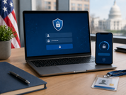 A laptop and smartphone display secure login icons on a desk with an ID badge, notebook, plant, U.S. flag, and blurred government building.