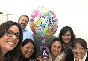 group of people posing for a photo in an office