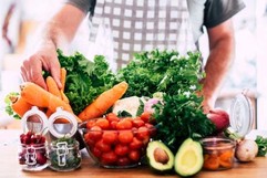 a man standing behind a table of produce