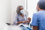 Woman in mask meeting with health care professional