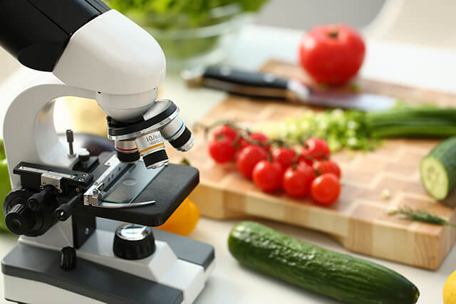 microscope along with a cucumber and tomatoes 