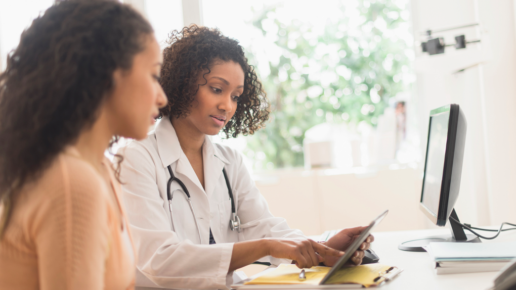 African American Woman Speaking to African American Female at Doctor's Office